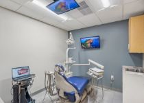 Wayne dentist standing next to computer monitor in dental treatment room