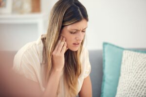 Woman holding hand to jaw in pain